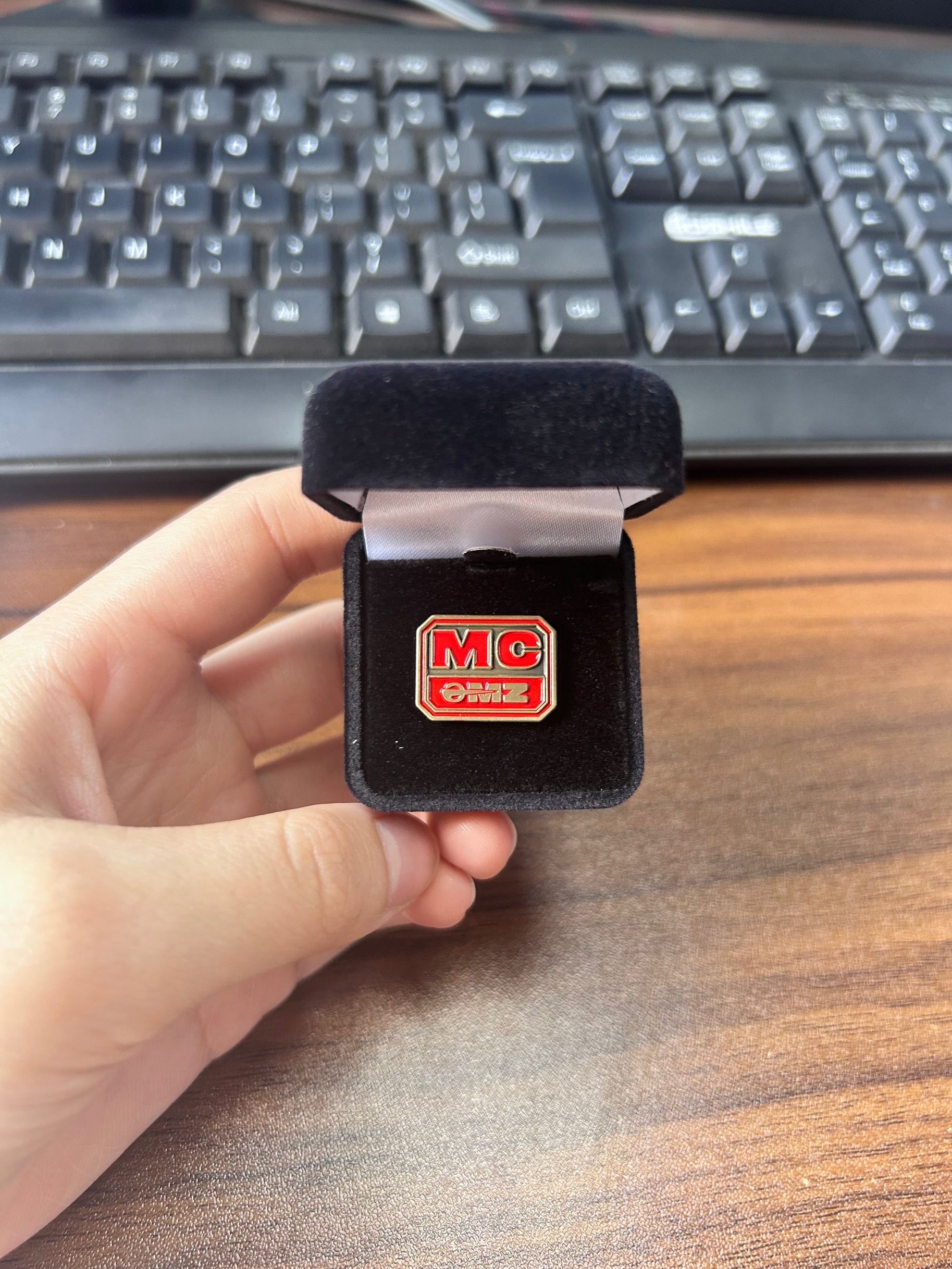 Red MC enamel pin in velvet box